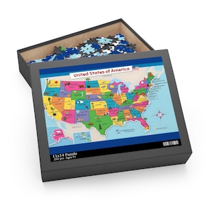 Può includere: Un puzzle da 28x36 cm in scatola con una mappa colorata degli Stati Uniti d'America. La scatola del puzzle è grigia e contiene pezzi di puzzle sfusi. La mappa mostra ogni stato con un colore diverso. La scatola include anche il testo "252 pezzi Età 9+".