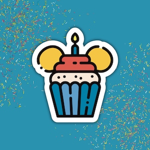 Op de afbeelding: Een gestanste sticker met een gestileerde cupcake met een blauwe wikkel, witte glazuur en een rode bovenkant. Twee gele cirkelvormige figuren bevinden zich aan weerszijden van het glazuur en een blauwe kaars met een gele vlam staat bovenop.