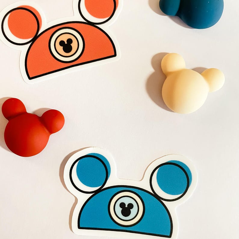 Two waterproof vinyl Mickey hat stickers in and dark teal and orange-rust colors, part of a collection of Disney stickers for water bottles.