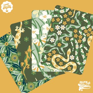 以下が含まれることがあります： 丸みを帯びた角を持つ4枚の装飾カード。植物や動物のデザインが特徴です。カードには、緑、黄、白の色合いの花、蝶、ヘビのパターンが示されています。「Hand Made」と「Guts & Glitter」の文字が見えます。