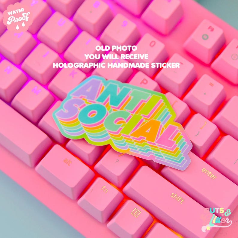 May include: A holographic sticker with the text "ANTI SOCIAL" in rainbow colors on a pink keyboard. The sticker is a handmade item and is water-proof.