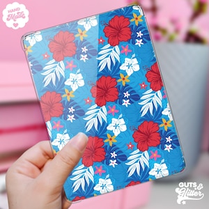 May include: A clear tablet case with a colourful floral design. The pattern showcases large red hibiscus flowers, white and yellow blossoms, and white and blue leaves against a bright blue backdrop. The words "Hand Made" and "Guts & Glitter" are also visible.