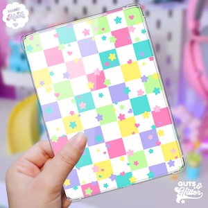 May include: A clear phone case with a checkered pattern in pastel pink, yellow, green, and purple. The case is decorated with small stars and hearts in various pastel colours.