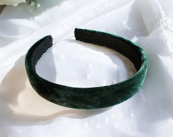 May include: A dark green velvet headband. The headband is on a white background.