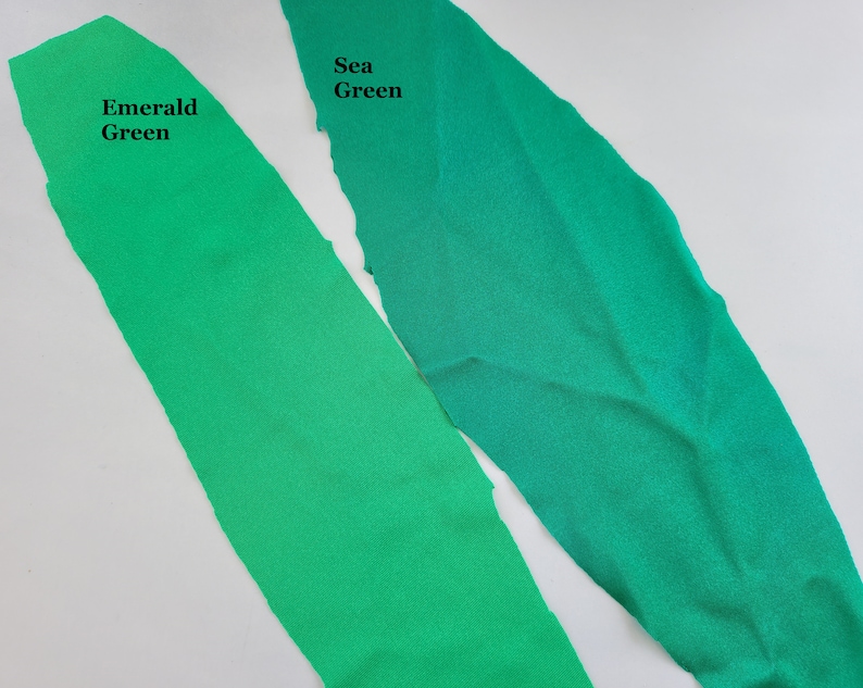 May include: Two fabric swatches, one emerald green and one sea green. The swatches are laid out side by side on a white surface.