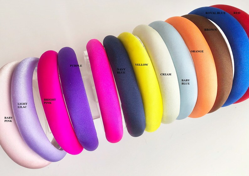May include: A set of 12 colorful headbands in various shades of pink, purple, blue, yellow, orange, brown, red, and cream. The headbands are made of a soft, padded material and are perfect for adding a pop of color to any outfit.
