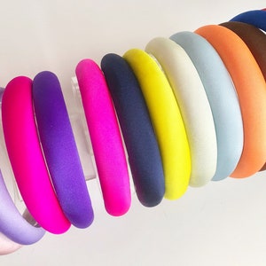 Può includere: Un set di 11 fasce per capelli in raso colorate in varie tonalità di rosa, viola, blu, giallo, bianco, arancione, marrone e rosso.