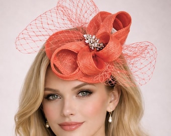 Tocado con lazo de sinamay color coral, rosa y naranja, para bodas.