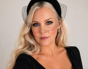 May include: A black velvet padded headband featuring a delicate black birdcage veil with a fine diamond-shaped mesh pattern. The veil extends across the front, covering the upper portion of the face with a structured, semi-sheer netting design.