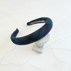 May include: A green and blue plaid headband with the text "Design by Hummingbird" on the back.