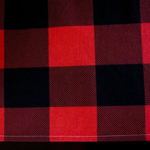 May include: Red and black buffalo plaid fabric with a white stitched edge.