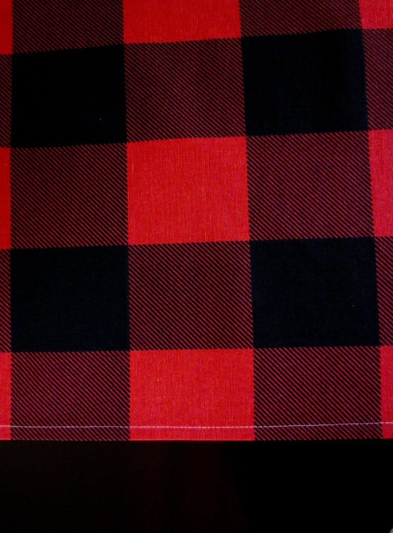 May include: Red and black buffalo plaid fabric with a white stitched edge.