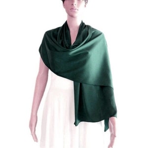 Può includere: Uno scialle o un coprispalle in raso verde scuro. Lo scialle è drappeggiato sulle spalle e sul collo di una persona.