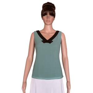 May include: A sleeveless top with a V-neckline and a black trim. The top is a light blue color.