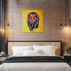 May include: A colorful painting of a bear on a yellow background. The bear is depicted with a variety of colors, including blue, red, and orange. The artwork is displayed on a wall above a bed with white bedding.