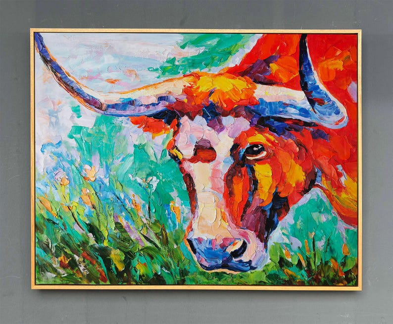 May include: A vibrant oil painting of a longhorn steer's head, framed in gold. The artwork features bold brushstrokes in shades of red, orange, blue, and green, creating a textured and expressive piece of art.