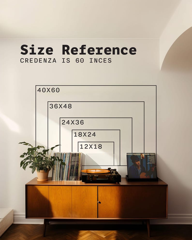 May include: A wall graphic displaying size reference rectangles labeled 12x18, 18x24, 24x36, 36x48, and 40x60 inches above a wooden credenza. The text reads Size Reference and Credenza is 60 inces. A record player, vinyl records, and a plant sit on top.