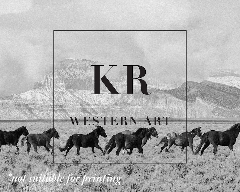 Puede incluir: Fotograf&iacute;a en blanco y negro de una manada de caballos salvajes corriendo a trav&eacute;s de un campo de hierba con una cordillera de monta&ntilde;as en el fondo. La imagen tiene una superposici&oacute;n de texto que dice "KR WESTERN ART" en una fuente sans-serif negra.