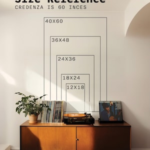 May include: A wall graphic showing size reference rectangles labelled 12x18, 18x24, 24x36, 36x48, and 40x60 inches above a wooden credenza. The text reads Size Reference and Credenza is 60 inces. A plant, vinyl records, and a record player are present.