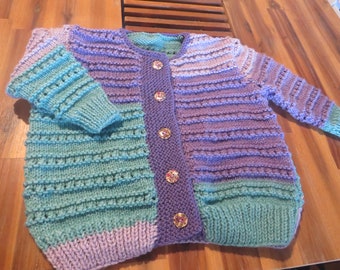 Beautifully hand knitted 20 per cent  wool and 80 per cent  acrylic  cardigan with painted wooden buttons. Size to fit 12 to 18 months.