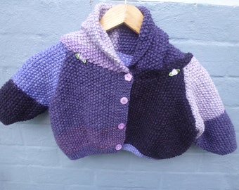 Beautifully hand knitted  in moss stitch. Warm and cozy acrylic babies hooded jacket to fit 6 to 9 months old baby. Purple tones.