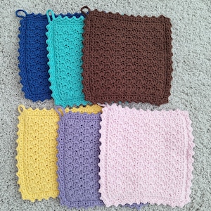 May include: A collection of seven crocheted square potholders in various colors, including blue, teal, brown, yellow, purple, and pink. Each potholder has a scalloped edge and a loop for hanging.