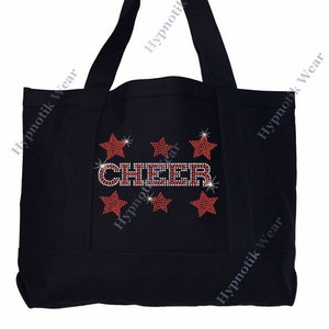 May include: Black canvas tote bag with the word "CHEER" in red and silver rhinestones. The word is surrounded by six red and silver rhinestone stars.