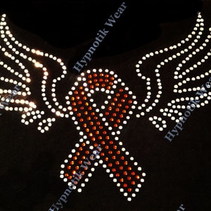 May include: A red and orange ribbon with white rhinestones, surrounded by two white wings with rhinestones. The design is on a black background and says "Hypnotik Wear" on the top and bottom.