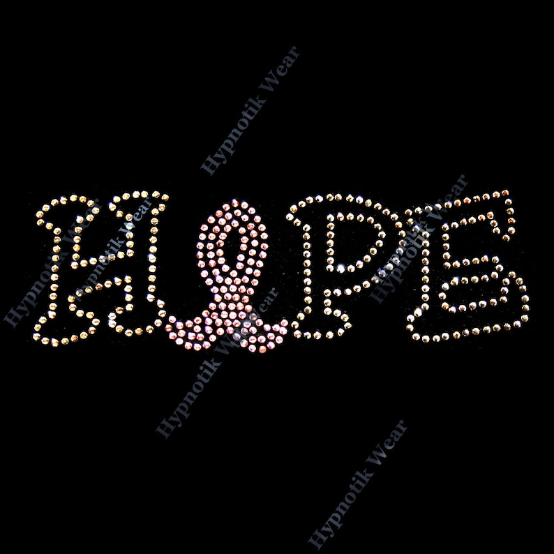 May include: HOPE spelled out in rhinestones with a pink ribbon in the center. The rhinestones are clear and pink.