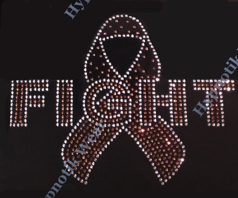 May include: A brown ribbon made of rhinestones with the word "FIGHT" in rhinestones on a black background.