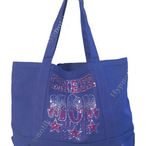 May include: A royal blue canvas tote bag with the words "Cheer Mom" in pink rhinestones and silver glitter stars.