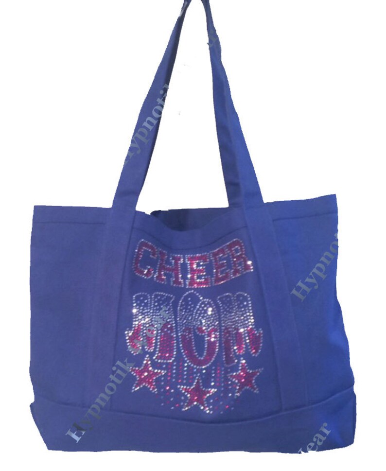 May include: A royal blue canvas tote bag with the words "Cheer Mom" in pink rhinestones and silver glitter stars.