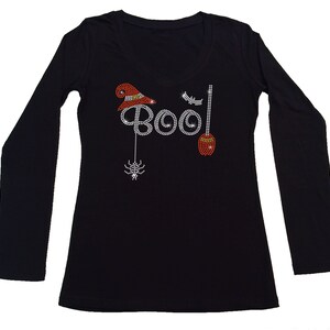 Peut inclure: T-shirt &agrave; manches longues noire avec un motif en strass repr&eacute;sentant un chapeau de sorci&egrave;re, un balai, une araign&eacute;e et le mot "BOO!"
