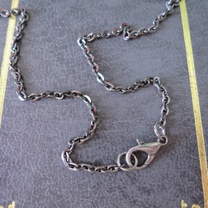 Pu&ograve; includere: Una collana a catena d'argento con chiusura a moschettone.