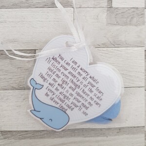K&ouml;nnte beinhalten: Eine wei&szlig;e herzf&ouml;rmige Karte mit einer blauen Walillustration und dem Text "Ich bin ein Sorgenwal. Du kannst mir all deine &Auml;ngste erz&auml;hlen, wenn deine Angst &uuml;bertrieben ist. Ich werde zuh&ouml;ren, obwohl ich keine Ohren habe. Halte mich fest und dr&uuml;cke mich. Sag mir, was dich besch&auml;ftigt. Alles wird gut, du wirst sehen. Jede Wolke kann silbern sein."