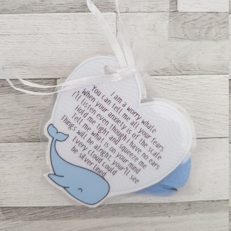 K&ouml;nnte beinhalten: Eine wei&szlig;e herzf&ouml;rmige Karte mit einer blauen Walillustration und dem Text "Ich bin ein Sorgenwal. Du kannst mir all deine &Auml;ngste erz&auml;hlen, wenn deine Angst &uuml;bertrieben ist. Ich werde zuh&ouml;ren, obwohl ich keine Ohren habe. Halte mich fest und dr&uuml;cke mich. Sag mir, was dich besch&auml;ftigt. Alles wird gut, du wirst sehen. Jede Wolke kann silbern sein."