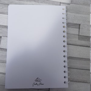 May include: White spiral bound notebook with the text "Etive Jewellery Planner" and a mountain graphic printed on the back cover.