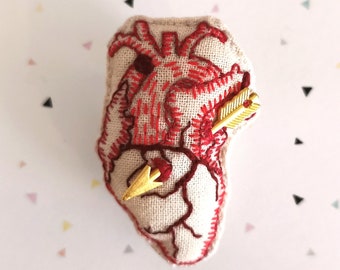 Anatomical heart brooch with and without cupids' arrow