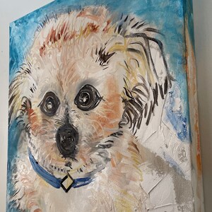 Puede incluir: Una pintura de un perro peque&ntilde;o, blanco con pelo marr&oacute;n y negro. El perro lleva un collar azul con una hebilla en forma de diamante. El fondo es un dise&ntilde;o abstracto azul claro y blanco.