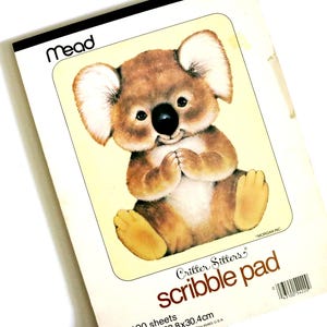 May include: A vintage "Critter Sitters" scribble pad featuring a cartoon koala bear illustration. The pad has 100 sheets and measures 9x12 inches. The cover has the "Mead" logo and the text "scribble pad" in a playful font. The koala is brown with a black nose.