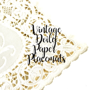 May include: A white paper doily featuring an intricate die-cut lace pattern with scalloped edges. The text "Vintage Doily Paper Placemats" is printed in black cursive script across the center of the decorative paper surface.