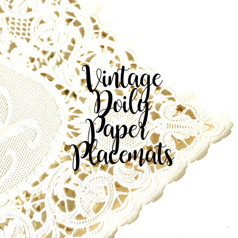 May include: A white paper doily featuring an intricate die-cut lace pattern with scalloped edges. The text "Vintage Doily Paper Placemats" is printed in black cursive script across the center of the decorative paper surface.