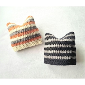 May include: Two crocheted hats with striped patterns. One hat is orange, white, and gray. The other hat is black and gray.