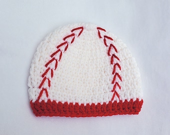 May include: White crocheted baseball hat with red stitching. The hat has a red crocheted brim.