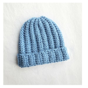 May include: A light blue crocheted beanie hat with a ribbed texture.