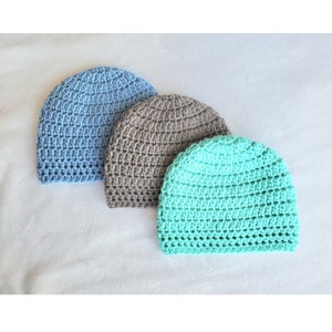May include: Three crocheted hats in different colors: light blue, gray, and teal.