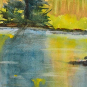 The shore foliage in the background is beginning to  turn to warm colors, from the first fall frost. This color is reflected into the lake.