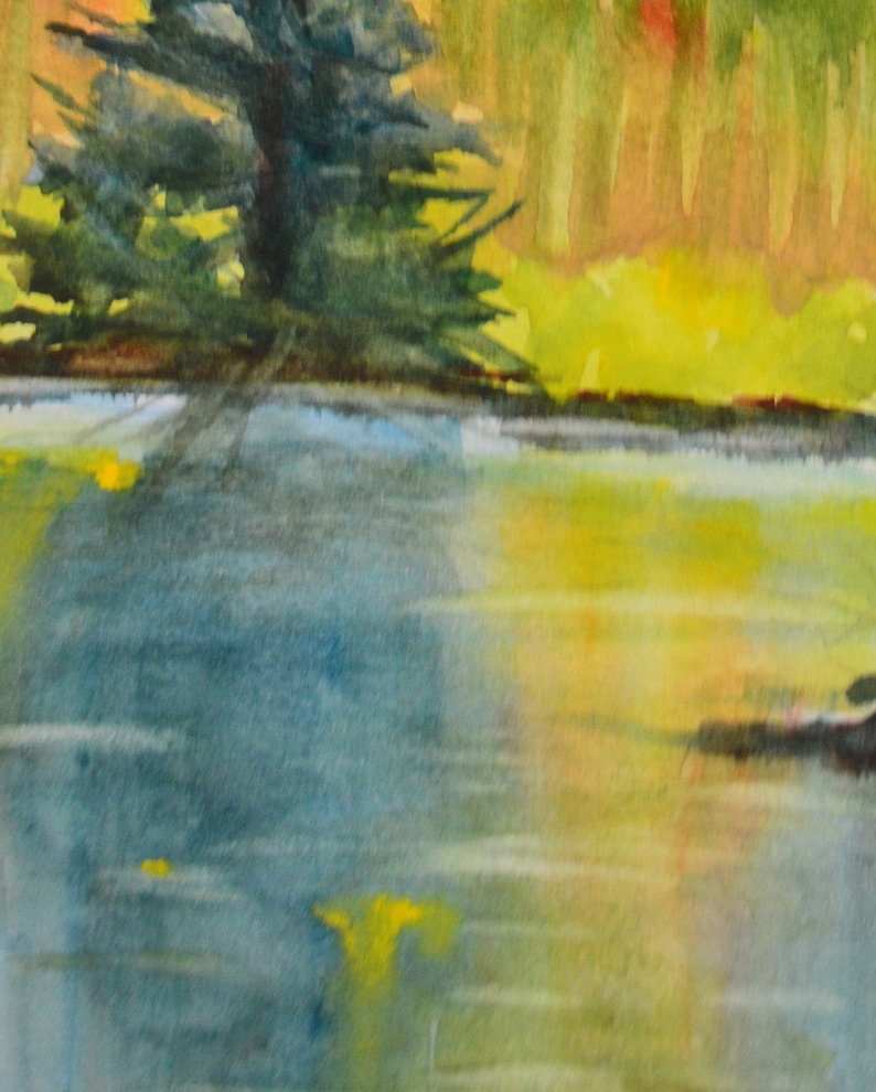 The shore foliage in the background is beginning to  turn to warm colors, from the first fall frost. This color is reflected into the lake.