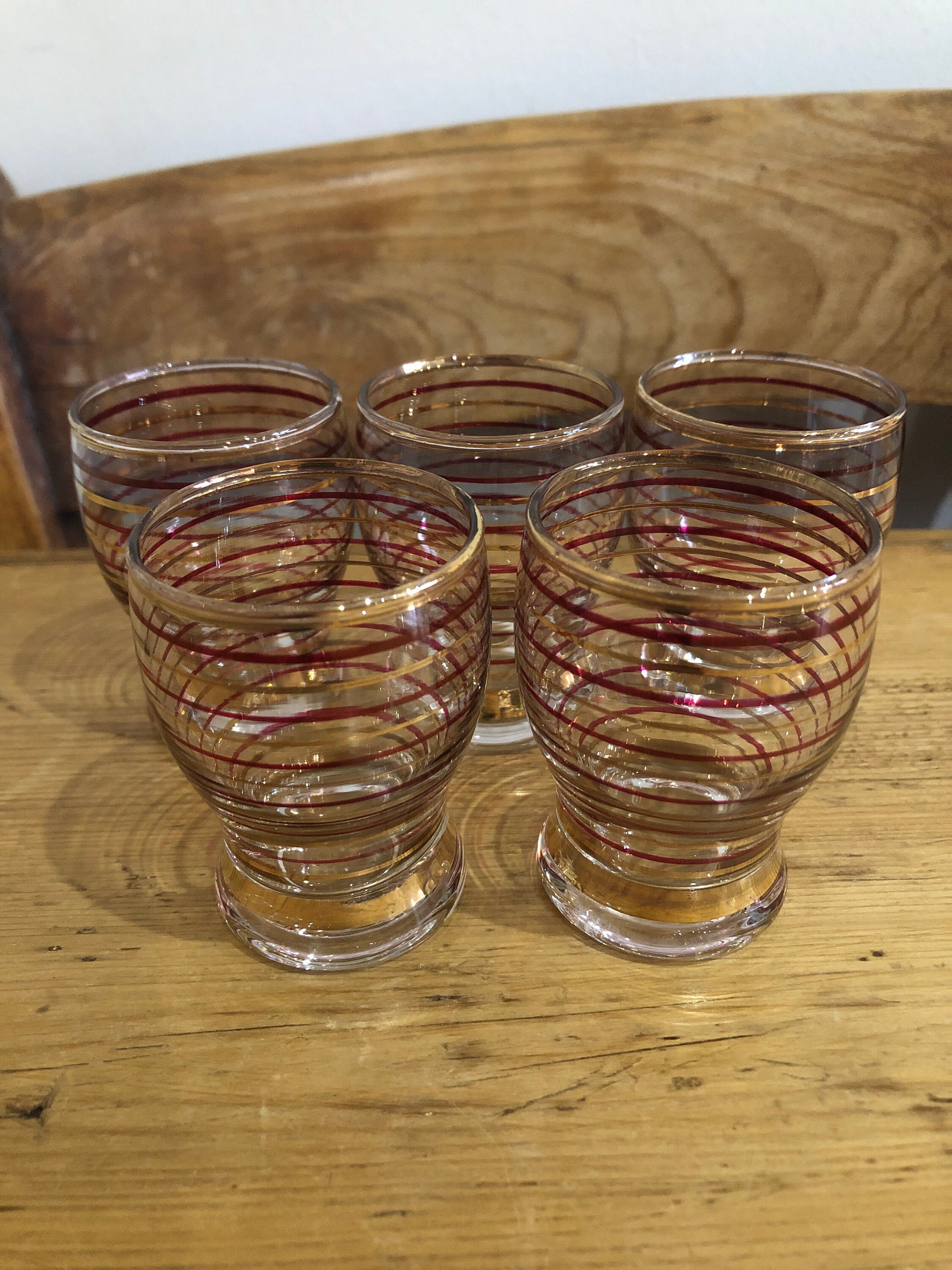 Juego de cinco copas de licor con aros rojos y dorados