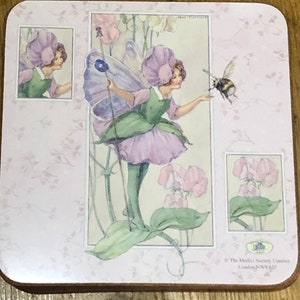 May include: A pink and green fairy with a flower crown and wings, holding a wand, stands in a field of pink flowers. A bee flies nearby. The image is from The Medici Society Limited, London, NW11 7JZ.